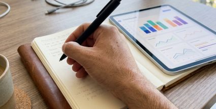 Notebook de cuero y tablet con dashboard de KPIs